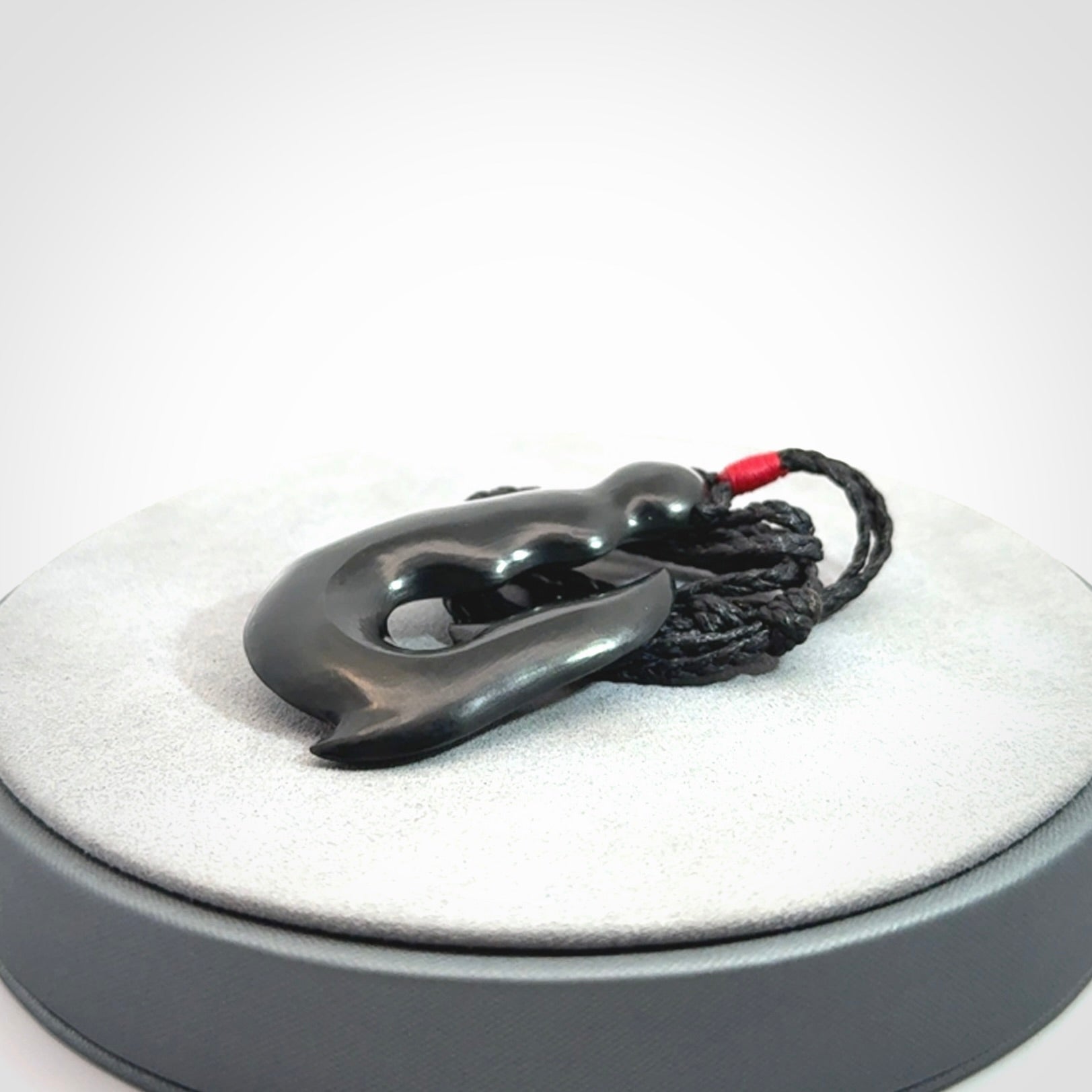 These pendants are hand carved, black jade hooks or matau pendants. They are beautifully finished in a polish and bound with adjustable necklace cords