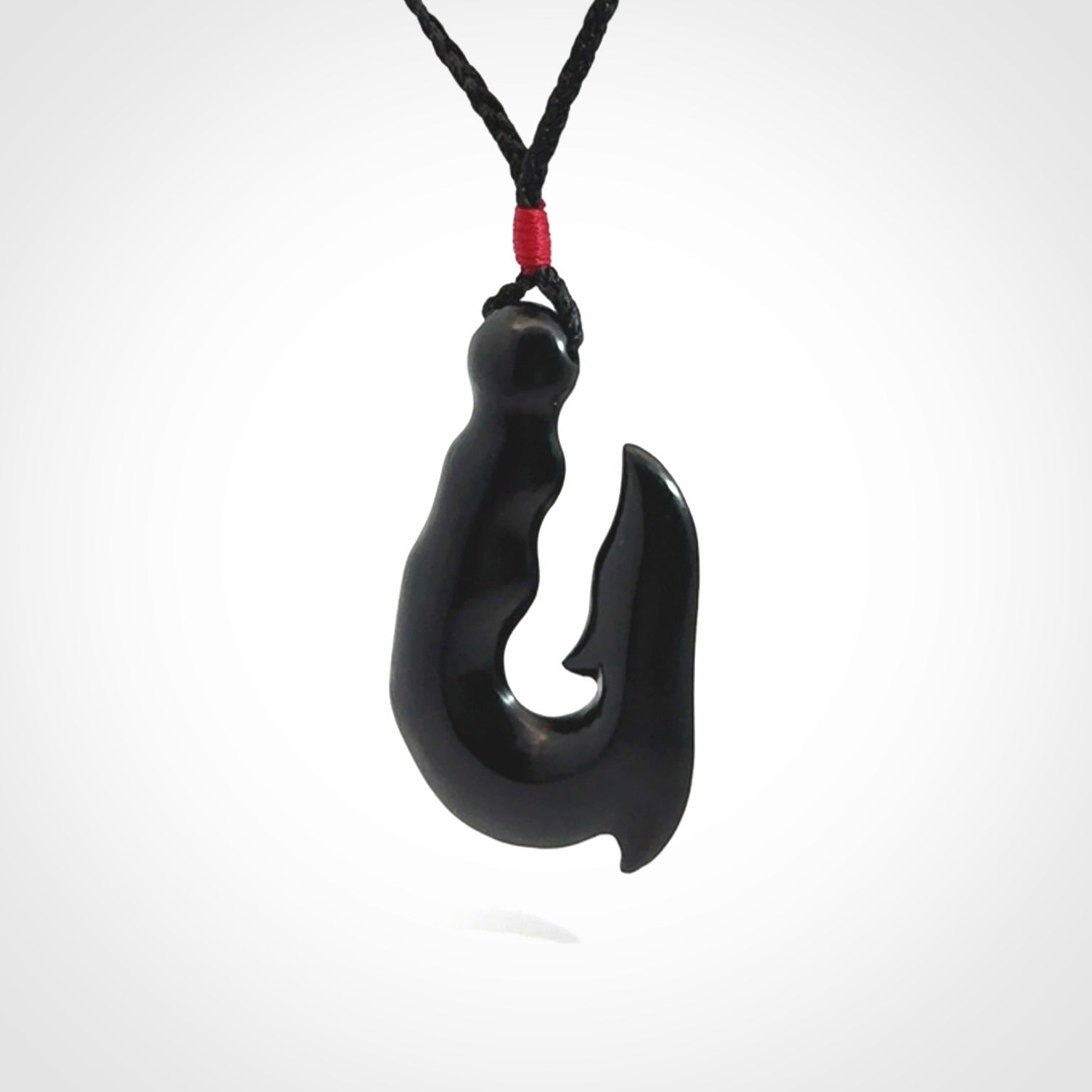 These pendants are hand carved, black jade hooks or matau pendants. They are beautifully finished in a polish and bound with adjustable necklace cords