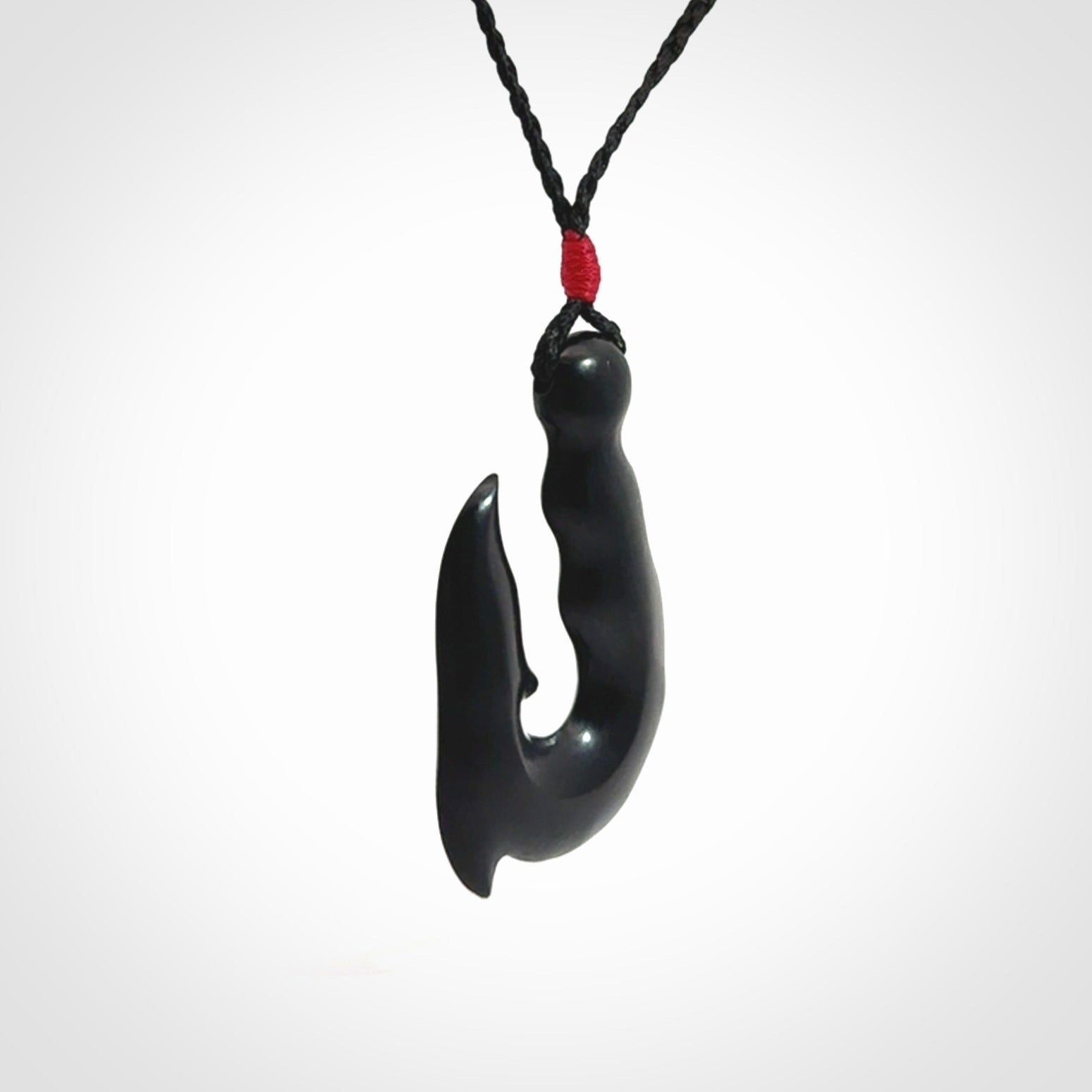 These pendants are hand carved, black jade hooks or matau pendants. They are beautifully finished in a polish and bound with adjustable necklace cords