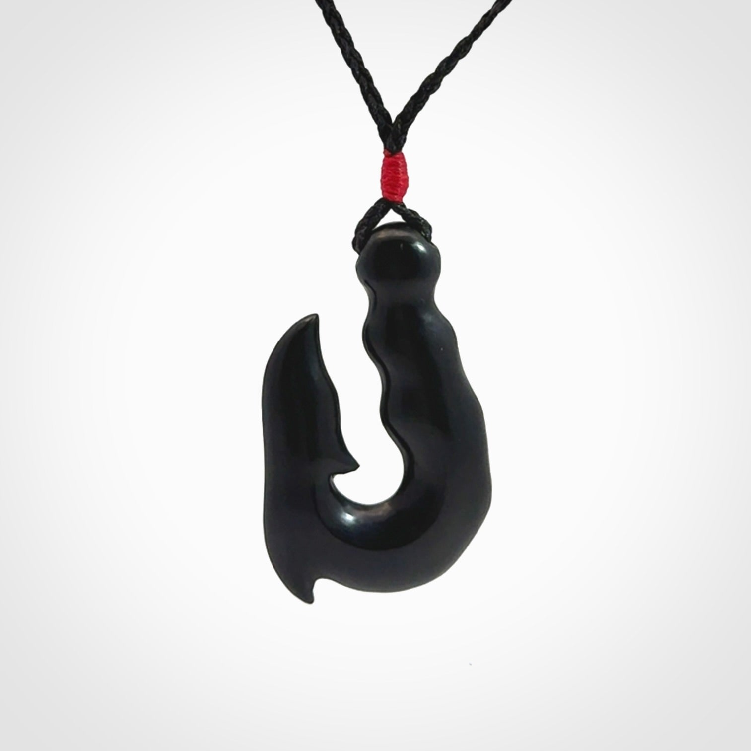 These pendants are hand carved, black jade hooks or matau pendants. They are beautifully finished in a polish and bound with adjustable necklace cords