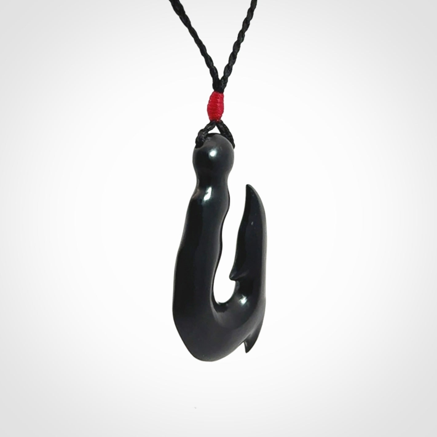 These pendants are hand carved, black jade hooks or matau pendants. They are beautifully finished in a polish and bound with adjustable necklace cords