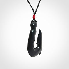 These pendants are hand carved, black jade hooks or matau pendants. They are beautifully finished in a polish and bound with adjustable necklace cords