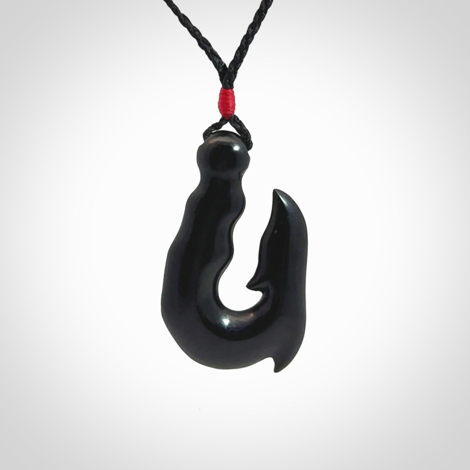 These pendants are hand carved, black jade hooks or matau pendants. They are beautifully finished in a polish and bound with adjustable necklace cords