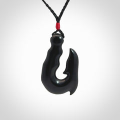 These pendants are hand carved, black jade hooks or matau pendants. They are beautifully finished in a polish and bound with adjustable necklace cords