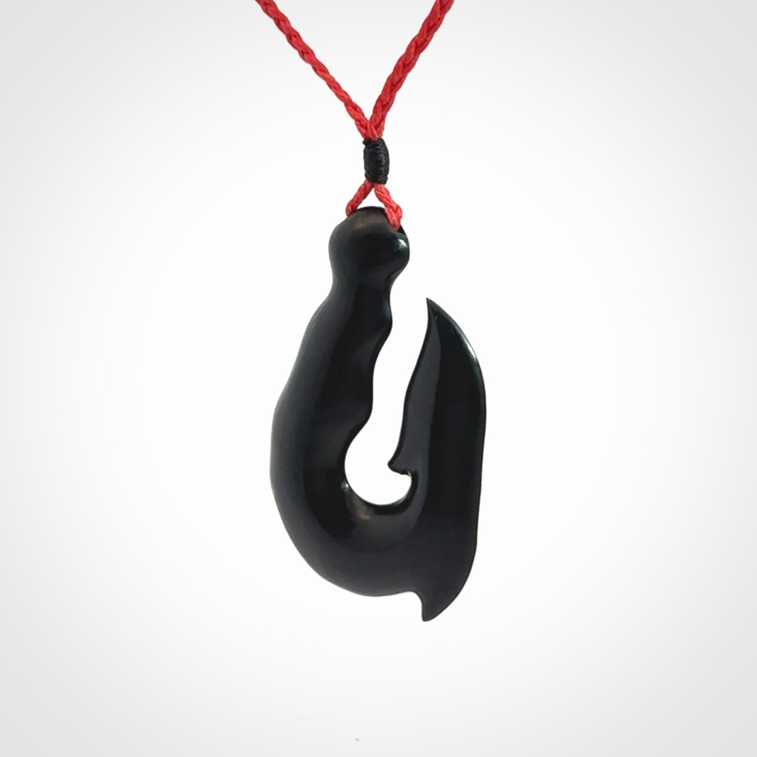 These pendants are hand carved, black jade hooks or matau pendants. They are beautifully finished in a polish and bound with adjustable necklace cords