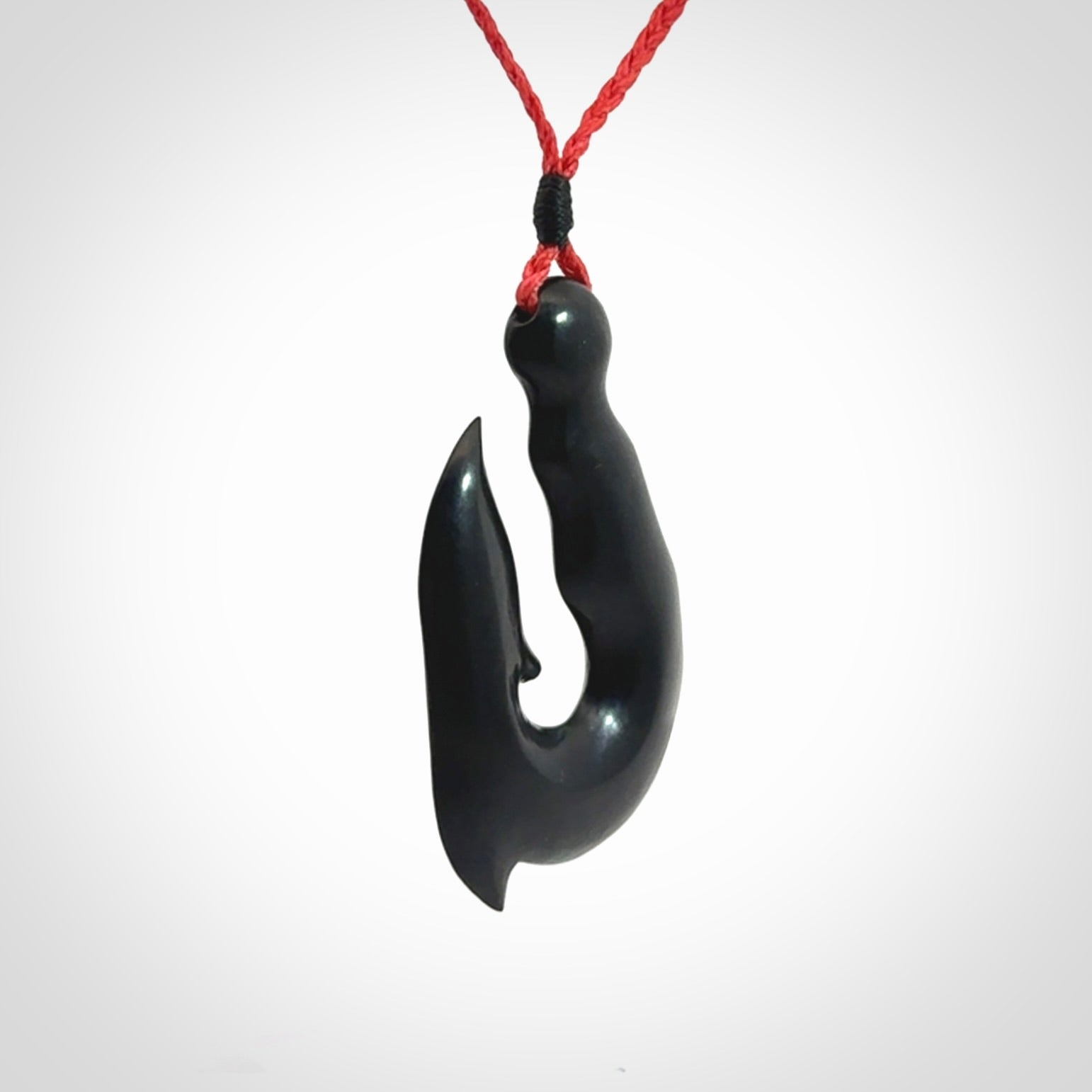 These pendants are hand carved, black jade hooks or matau pendants. They are beautifully finished in a polish and bound with adjustable necklace cords