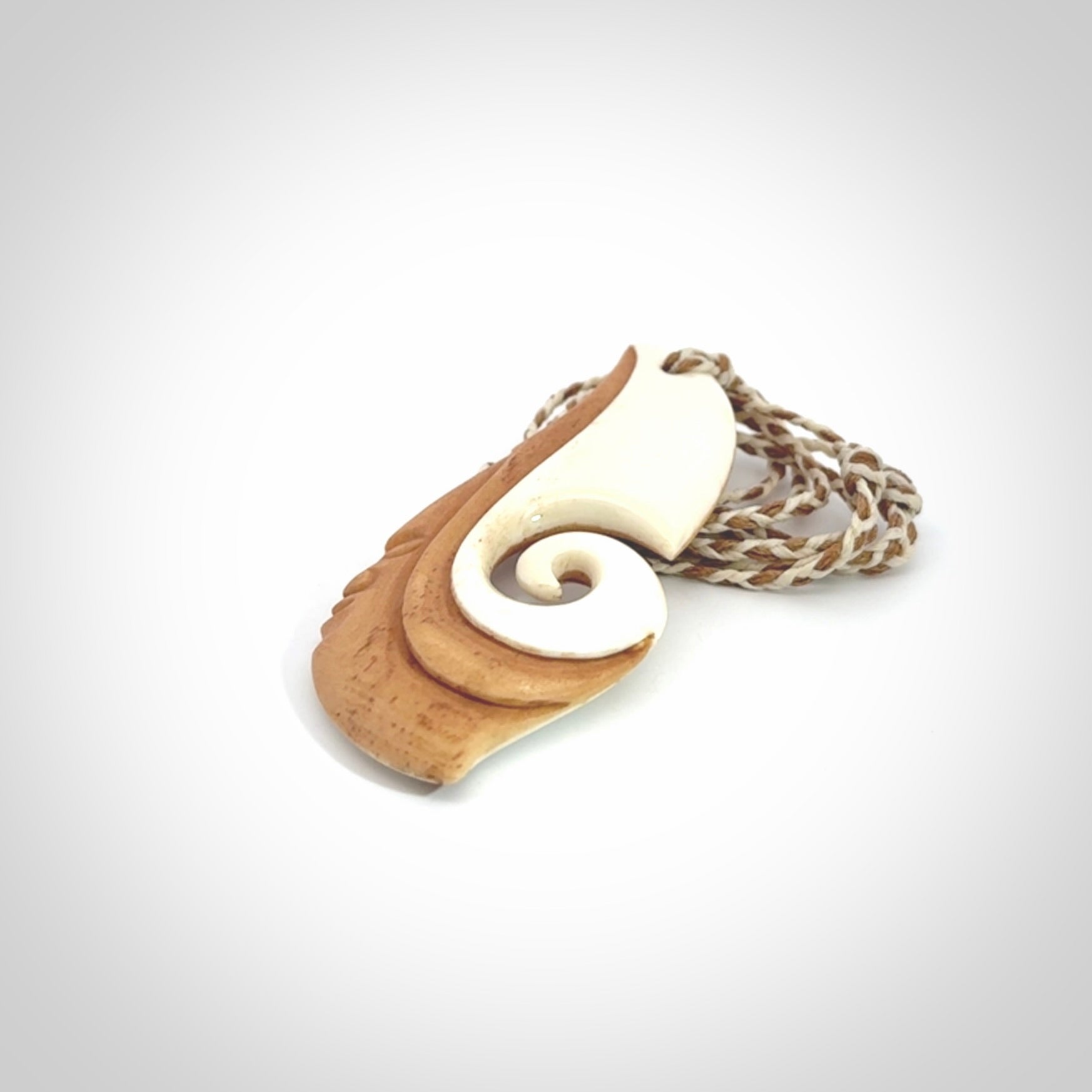A hand carved bone contemporary, intricate pendant. The cord is a 4 strand, 3 plait in Ice White and Tan and is an adjustable length. A large sized hand made contemporary necklace by New Zealand artist Kerry Thompson. Kerry has stained parts of the bone which really add to the dimension of this pendant. One of work of art to wear.