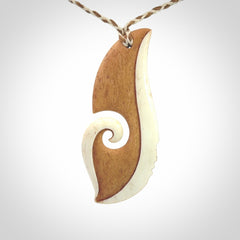 A hand carved bone contemporary, intricate pendant. The cord is a 4 strand, 3 plait in Ice White and Tan and is an adjustable length. A large sized hand made contemporary necklace by New Zealand artist Kerry Thompson. Kerry has stained parts of the bone which really add to the dimension of this pendant. One of work of art to wear.
