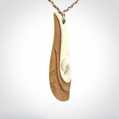 A hand carved bone contemporary, intricate pendant. The cord is a 4 strand, 3 plait in Ice White and Tan and is an adjustable length. A large sized hand made contemporary necklace by New Zealand artist Kerry Thompson. Kerry has stained parts of the bone which really add to the dimension of this pendant. One of work of art to wear.