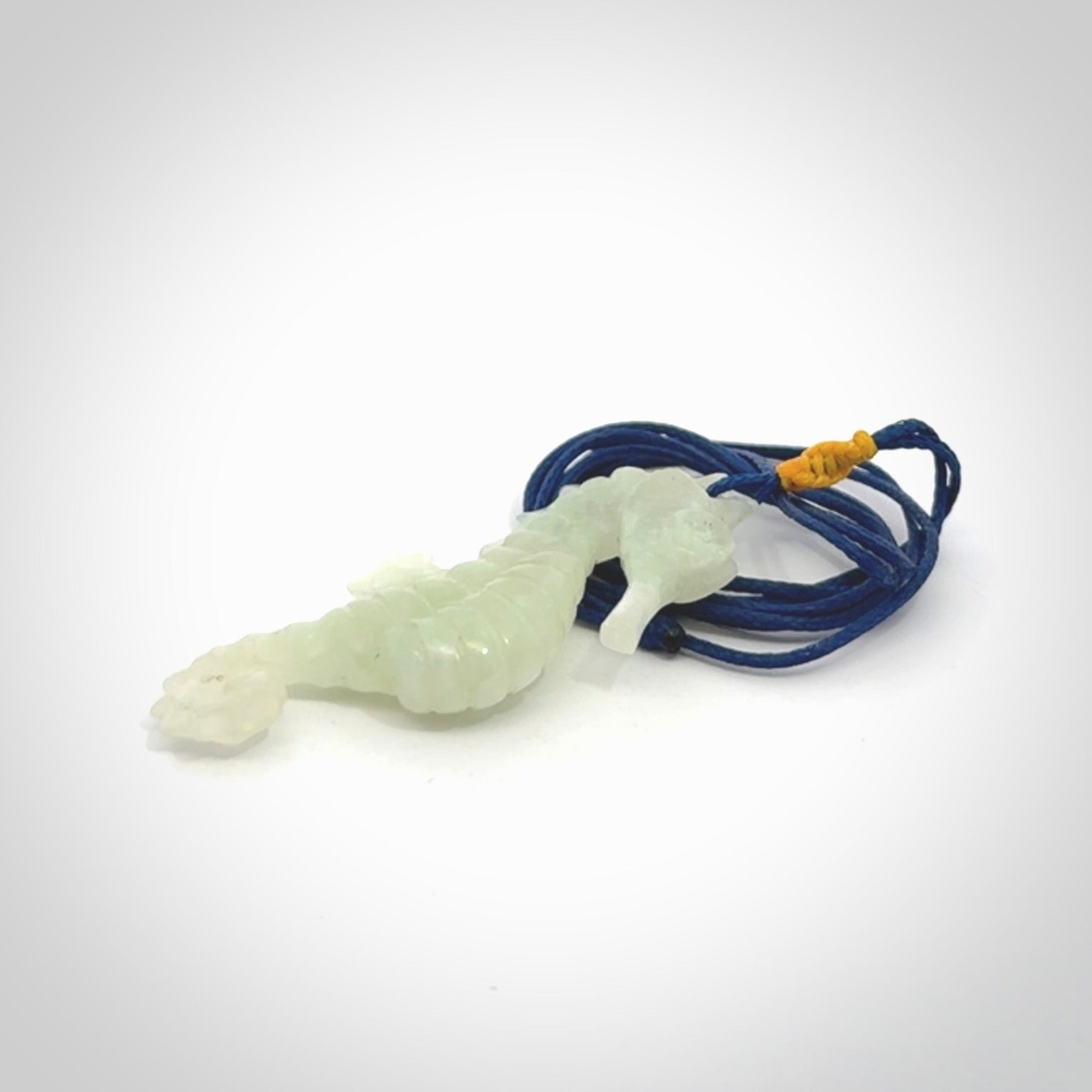 A hand carved Jadeite seahorse pendant. We have carved this from beautiful jadeite and we bind them with our Pacific Blue cords.