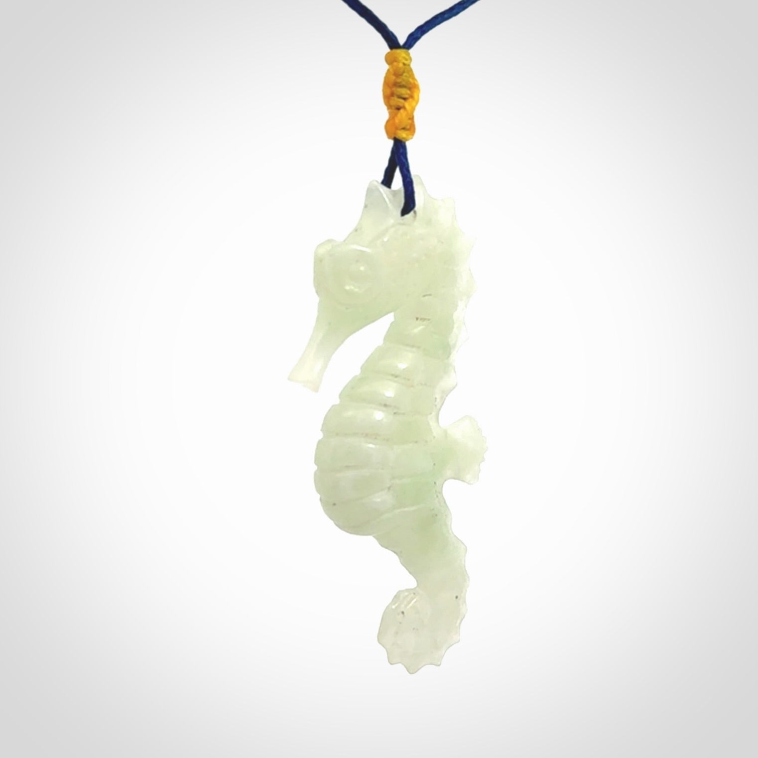 A hand carved Jadeite seahorse pendant. We have carved this from beautiful jadeite and we bind them with our Pacific Blue cords.