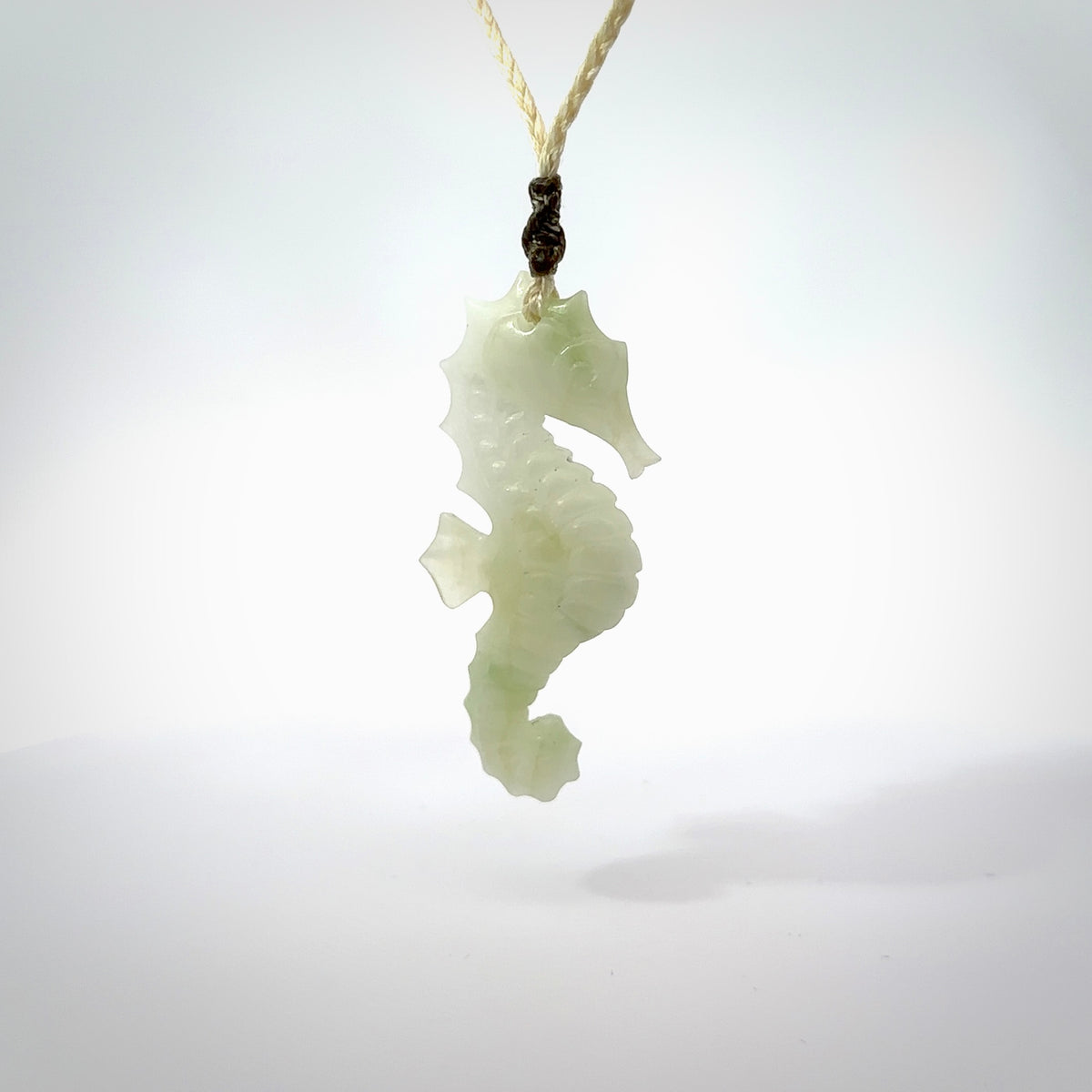 A hand carved Jadeite seahorse pendant. We have carved this from beautiful jadeite and we bind them with our hand-plaited cords. The cords are a waxed polyester so they are durable and strong. We ship these worldwide with express courier anywhere in the world.
