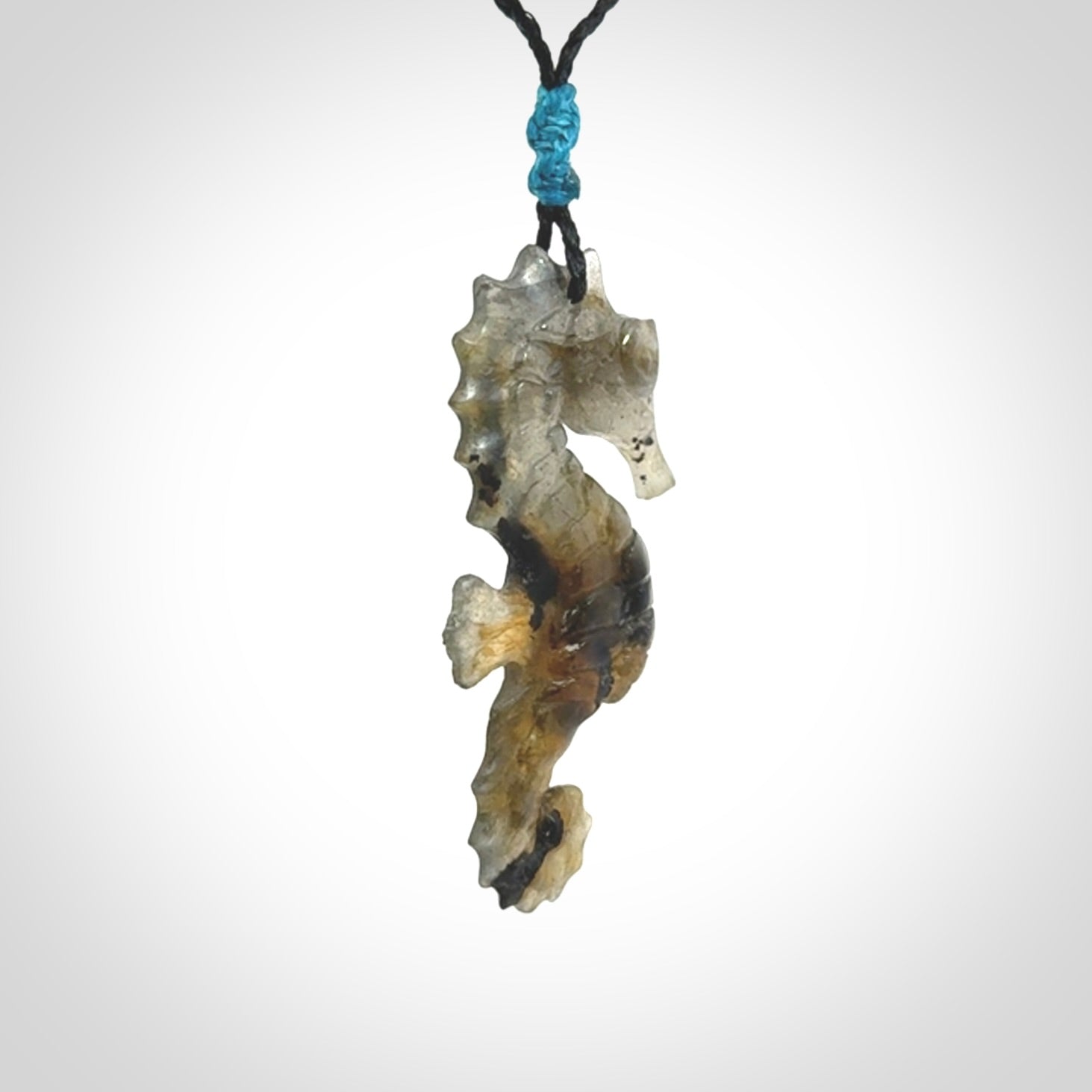 A hand carved labradorite seahorse pendant. We have carved this from beautiful labradorite and we bind them with our hand-plaited cords. The cords are a waxed polyester so they are durable and strong. We ship these worldwide with express courier anywhere in the world.