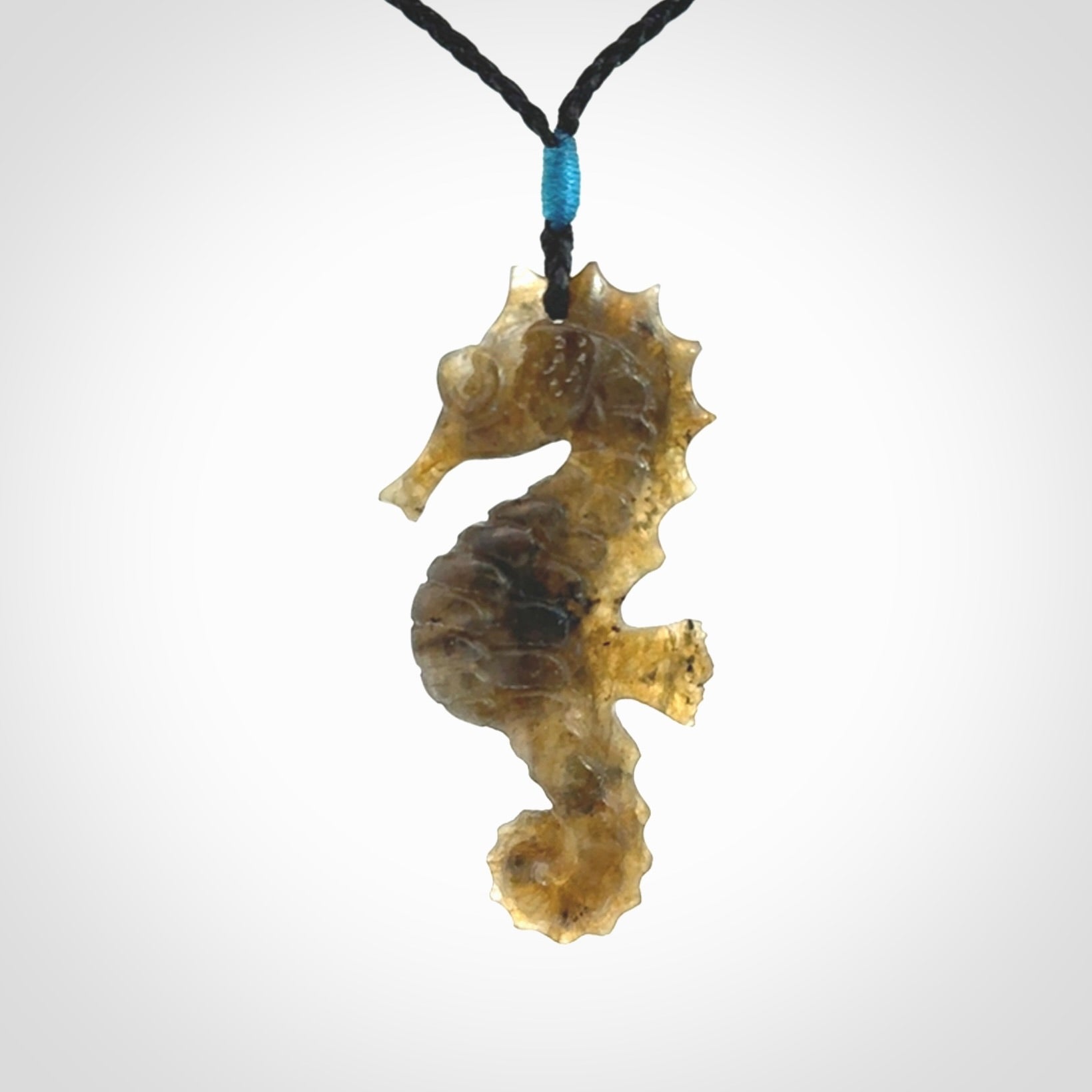 A hand carved labradorite seahorse pendant. We have carved this from beautiful labradorite and we bind them with our hand-plaited cords. The cords are a waxed polyester so they are durable and strong. We ship these worldwide with express courier anywhere in the world.