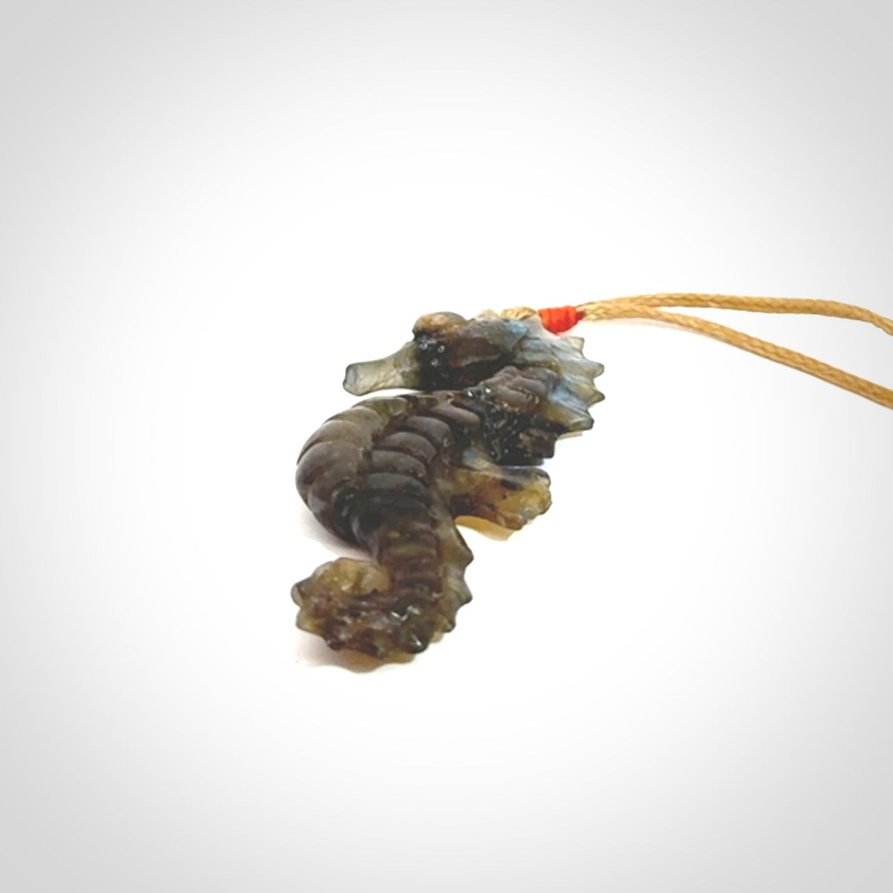 A hand carved labradorite seahorse pendant. We have carved this from beautiful labradorite and we bind them with our hand-plaited cords. The cords are a waxed polyester so they are durable and strong. We ship these worldwide with express courier anywhere in the world.