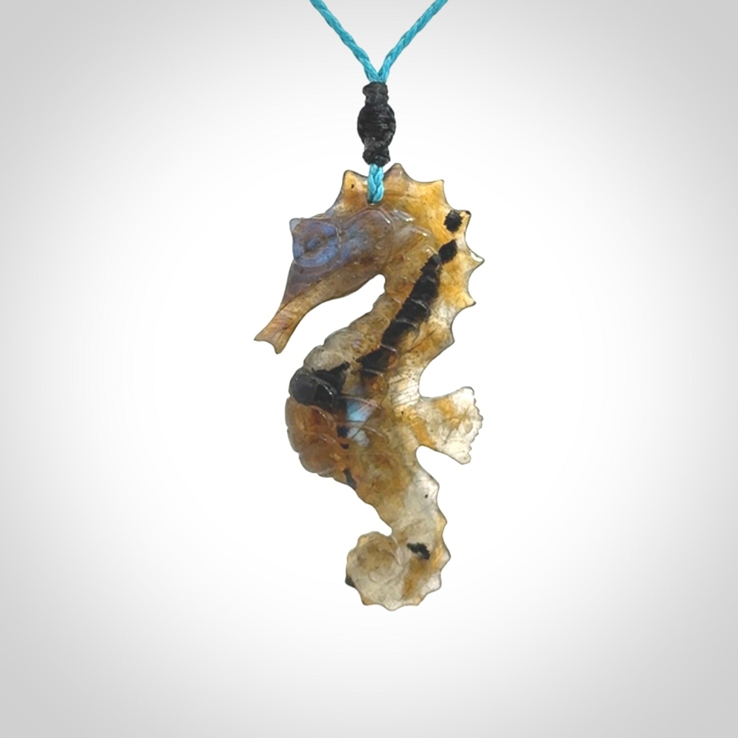 A hand carved labradorite seahorse pendant. We have carved this from beautiful labradorite and we bind them with our hand-plaited cords. The cords are a waxed polyester so they are durable and strong. We ship these worldwide with express courier anywhere in the world.