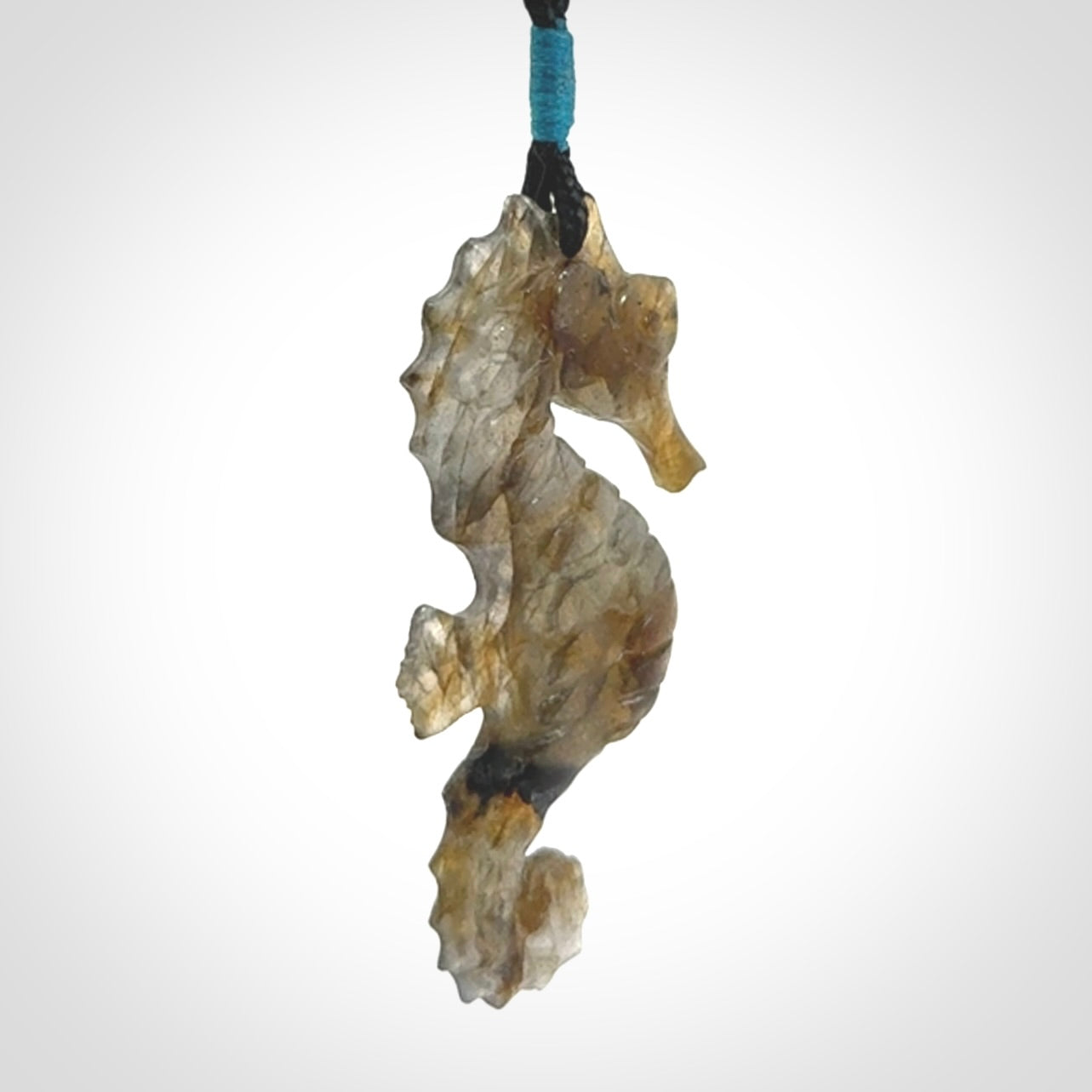A hand carved labradorite seahorse pendant. We have carved this from beautiful labradorite and we bind them with our hand-plaited cords. The cords are a waxed polyester so they are durable and strong. We ship these worldwide with express courier anywhere in the world.