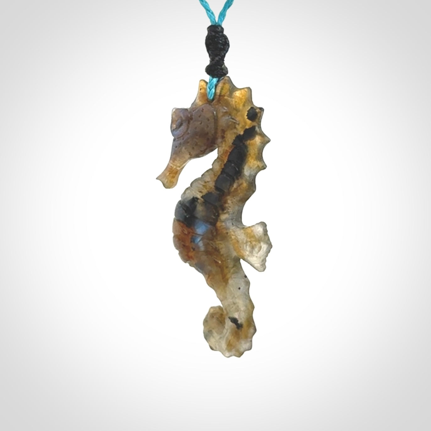 A hand carved labradorite seahorse pendant. We have carved this from beautiful labradorite and we bind them with our hand-plaited cords. The cords are a waxed polyester so they are durable and strong. We ship these worldwide with express courier anywhere in the world.