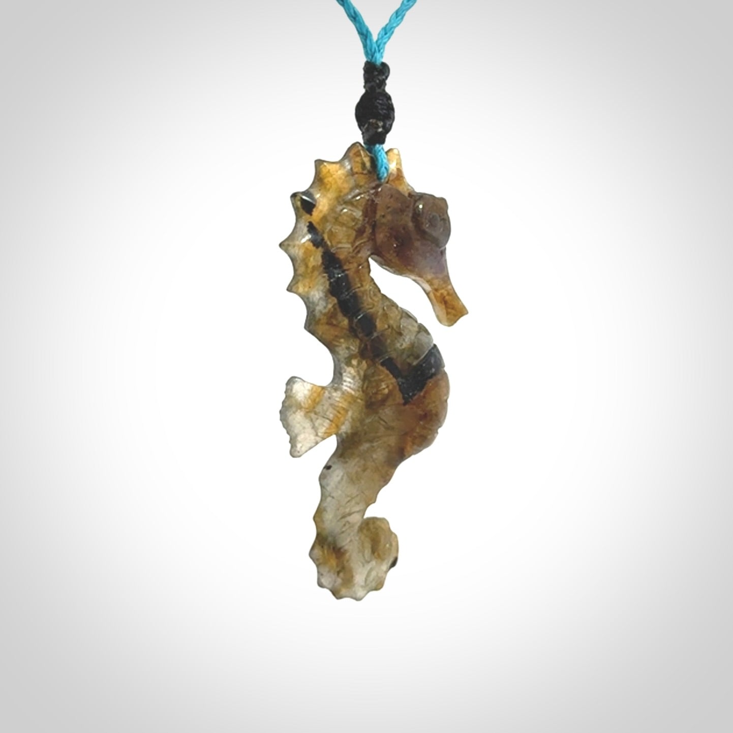 A hand carved labradorite seahorse pendant. We have carved this from beautiful labradorite and we bind them with our hand-plaited cords. The cords are a waxed polyester so they are durable and strong. We ship these worldwide with express courier anywhere in the world.