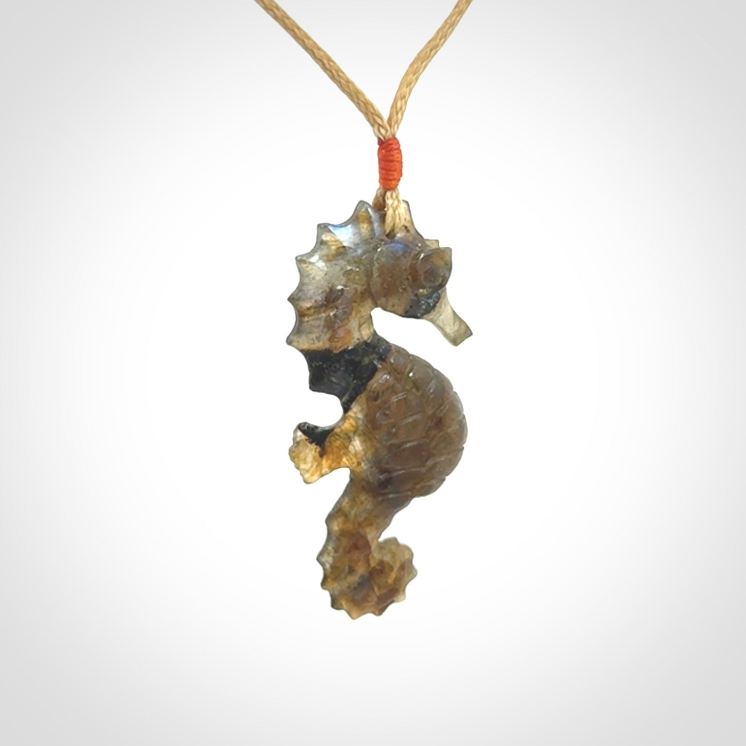 A hand carved labradorite seahorse pendant. We have carved this from beautiful labradorite and we bind them with our hand-plaited cords. The cords are a waxed polyester so they are durable and strong. We ship these worldwide with express courier anywhere in the world.