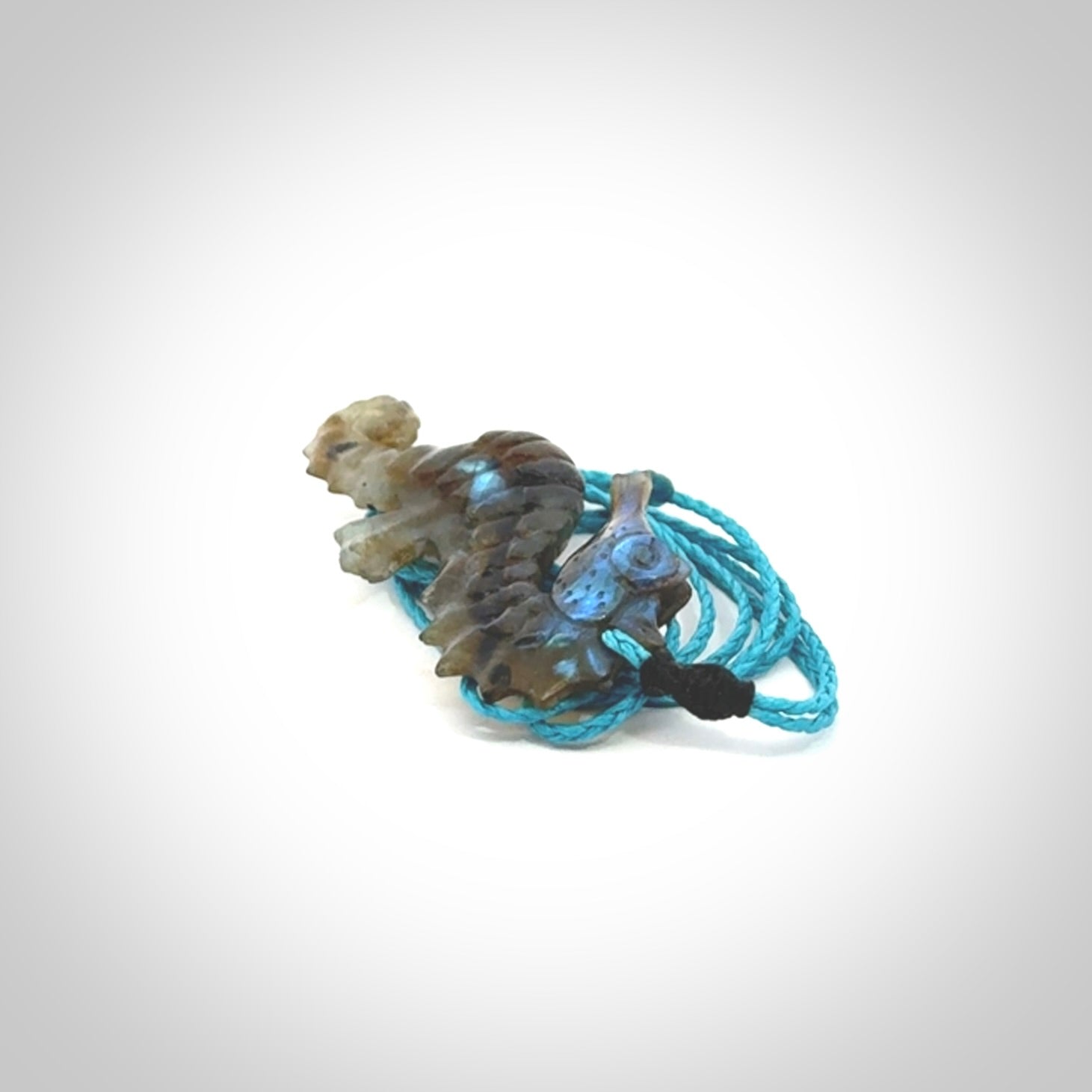 A hand carved labradorite seahorse pendant. We have carved this from beautiful labradorite and we bind them with our hand-plaited cords. The cords are a waxed polyester so they are durable and strong. We ship these worldwide with express courier anywhere in the world.