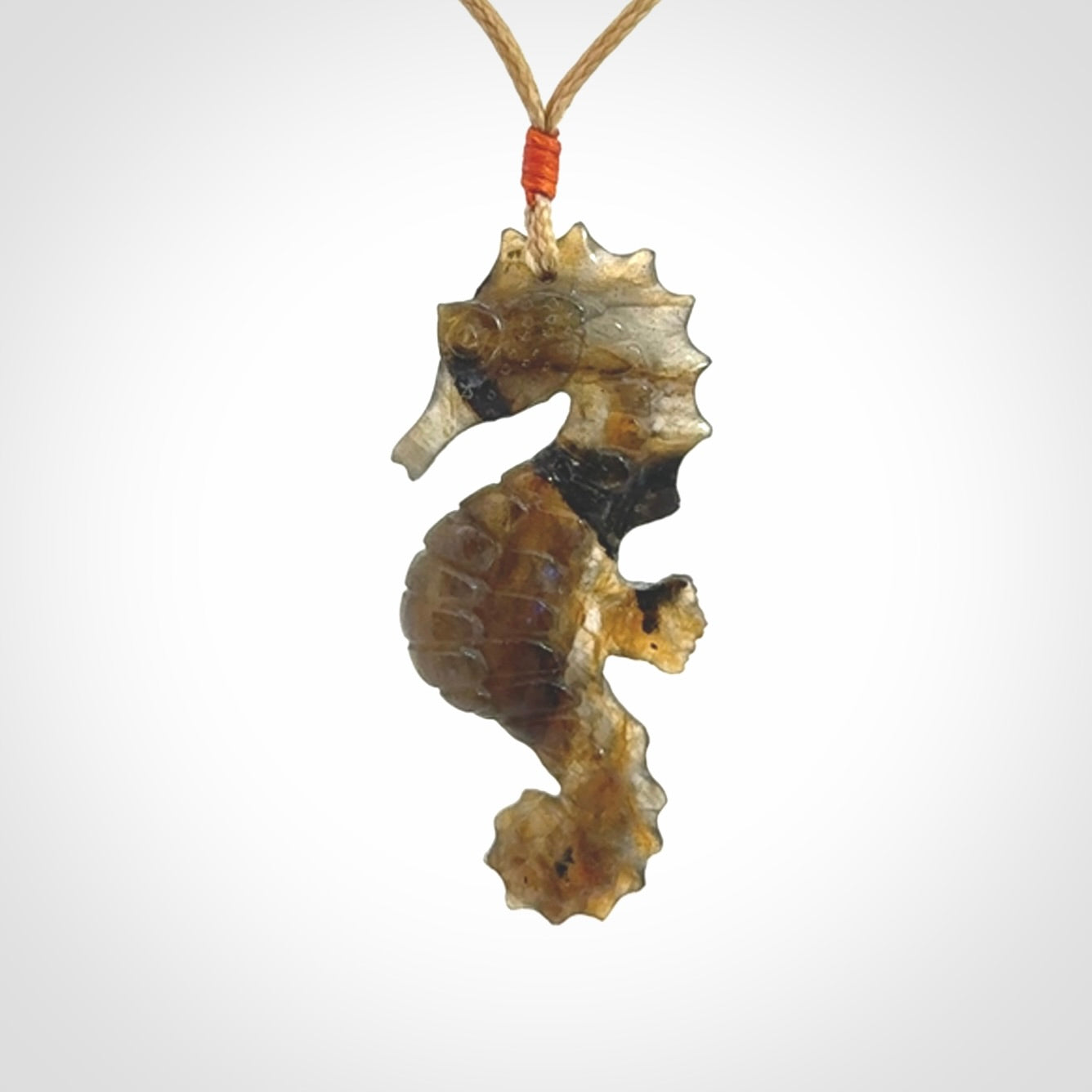 A hand carved labradorite seahorse pendant. We have carved this from beautiful labradorite and we bind them with our hand-plaited cords. The cords are a waxed polyester so they are durable and strong. We ship these worldwide with express courier anywhere in the world.