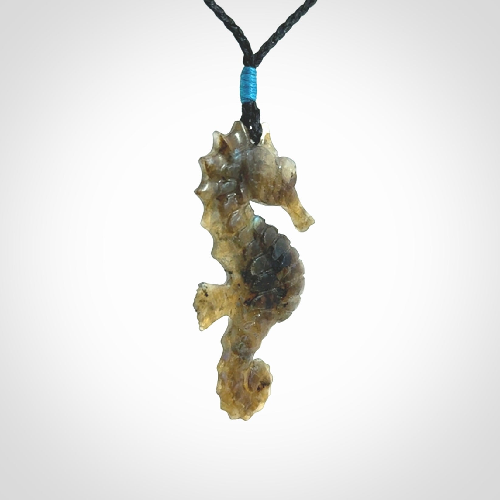 A hand carved labradorite seahorse pendant. We have carved this from beautiful labradorite and we bind them with our hand-plaited cords. The cords are a waxed polyester so they are durable and strong. We ship these worldwide with express courier anywhere in the world.