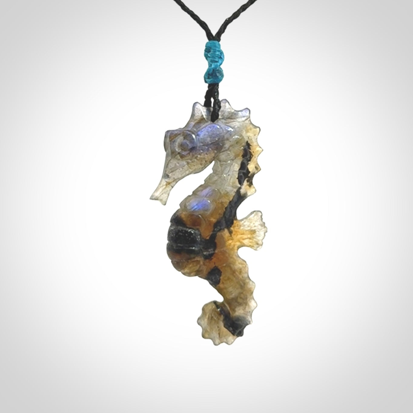 A hand carved labradorite seahorse pendant. We have carved this from beautiful labradorite and we bind them with our hand-plaited cords. The cords are a waxed polyester so they are durable and strong. We ship these worldwide with express courier anywhere in the world.
