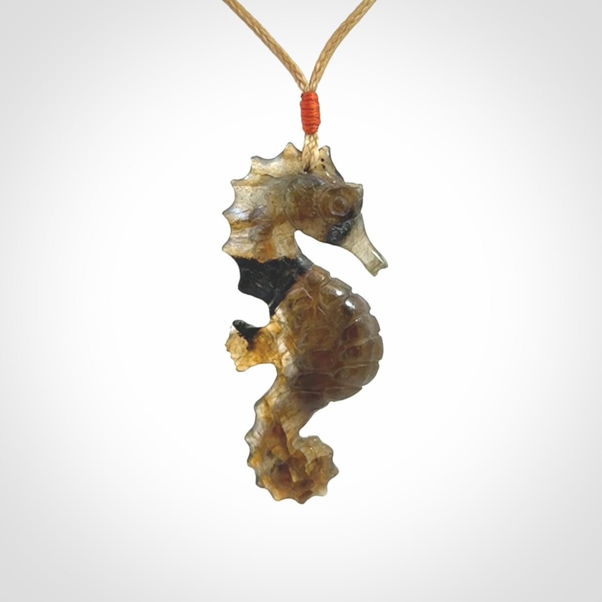 A hand carved labradorite seahorse pendant. We have carved this from beautiful labradorite and we bind them with our hand-plaited cords. The cords are a waxed polyester so they are durable and strong. We ship these worldwide with express courier anywhere in the world.