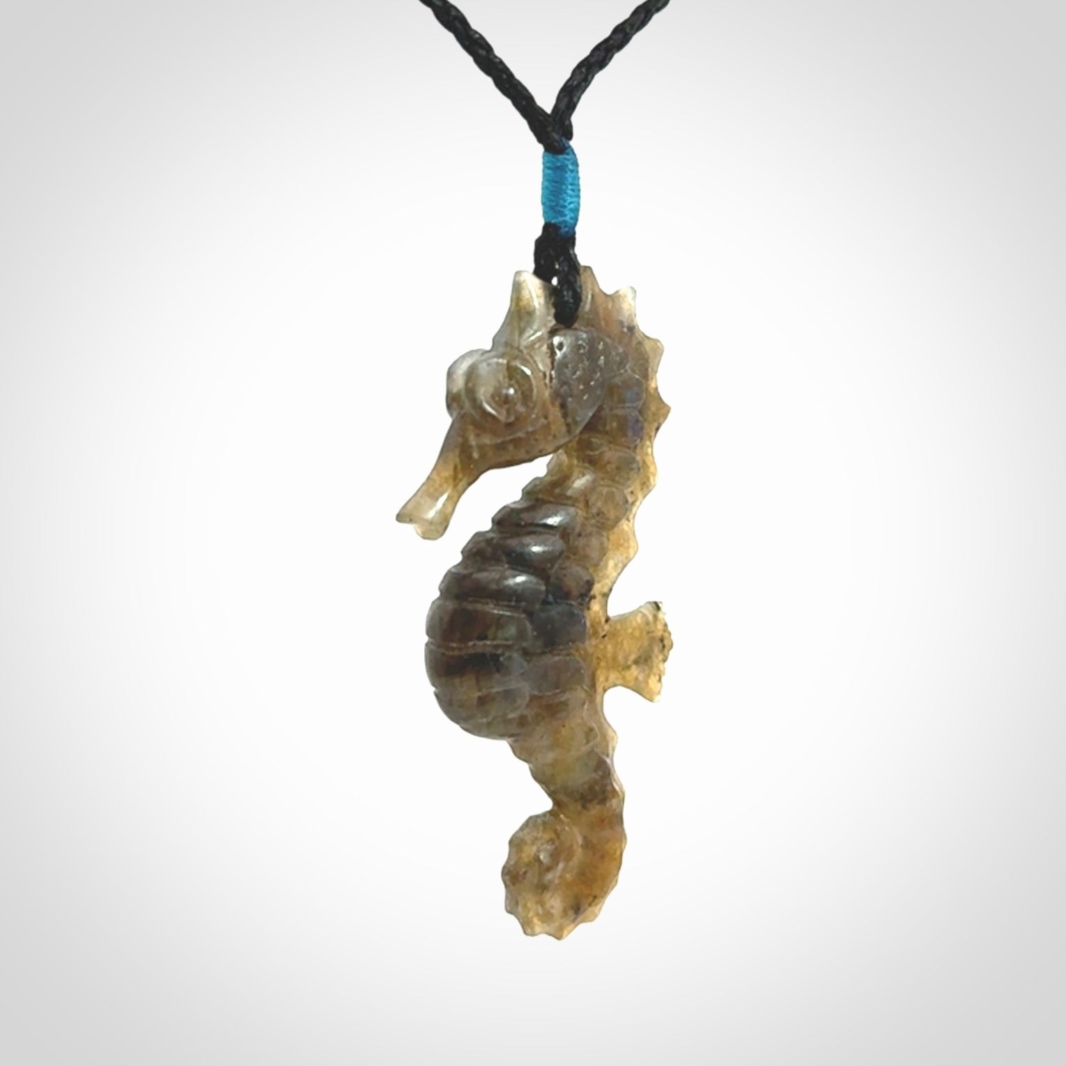 A hand carved labradorite seahorse pendant. We have carved this from beautiful labradorite and we bind them with our hand-plaited cords. The cords are a waxed polyester so they are durable and strong. We ship these worldwide with express courier anywhere in the world.