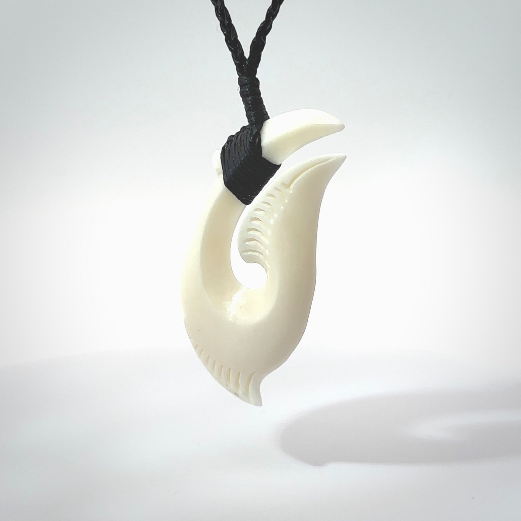 Hand carved cow bone hook pendant. Maori matau carving, hand carved jewellery for sale online.