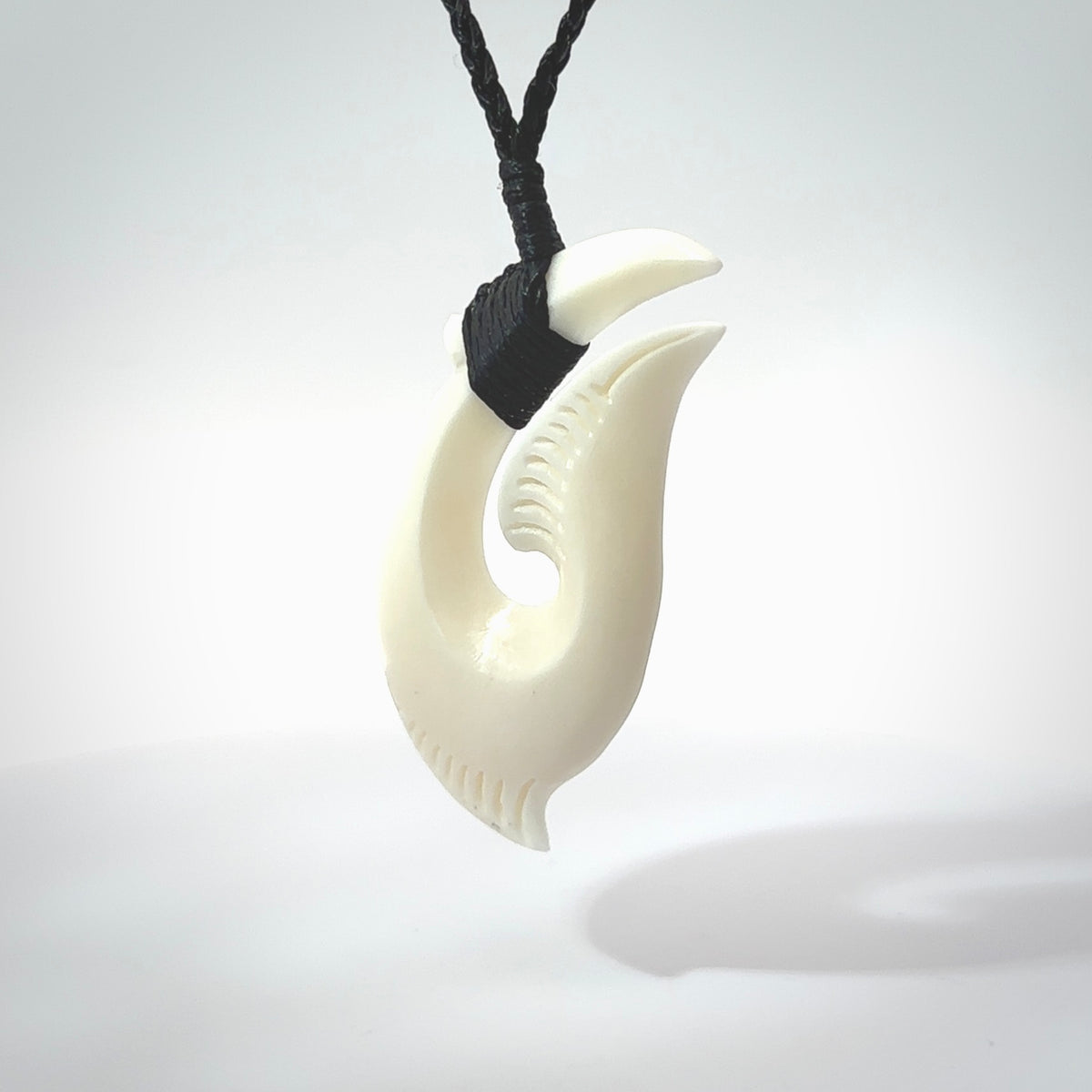 Hand carved cow bone hook pendant. Maori matau carving, hand carved jewellery for sale online.