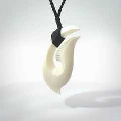 Hand carved cow bone hook pendant. Maori matau carving, hand carved jewellery for sale online.