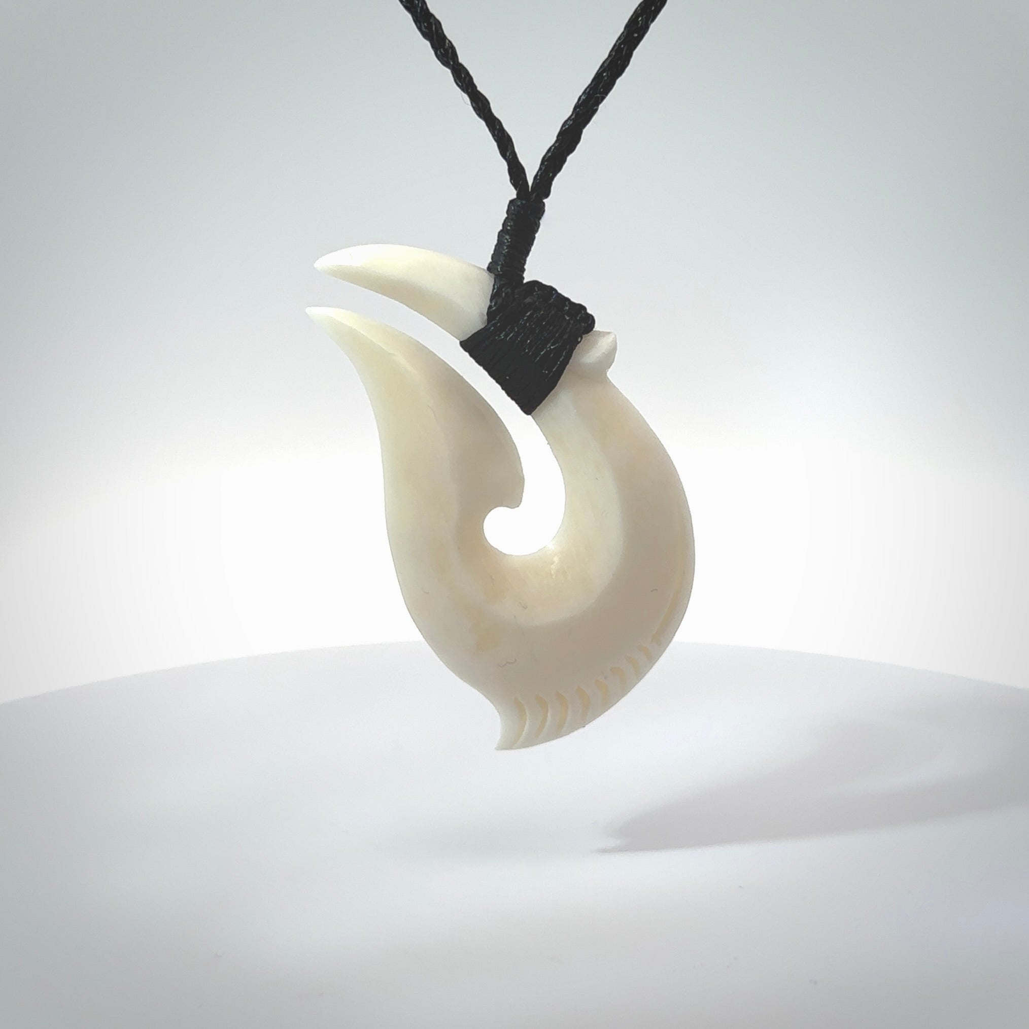 Hand carved cow bone hook pendant. Maori matau carving, hand carved jewellery for sale online.