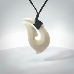 Hand carved cow bone hook pendant. Maori matau carving, hand carved jewellery for sale online.