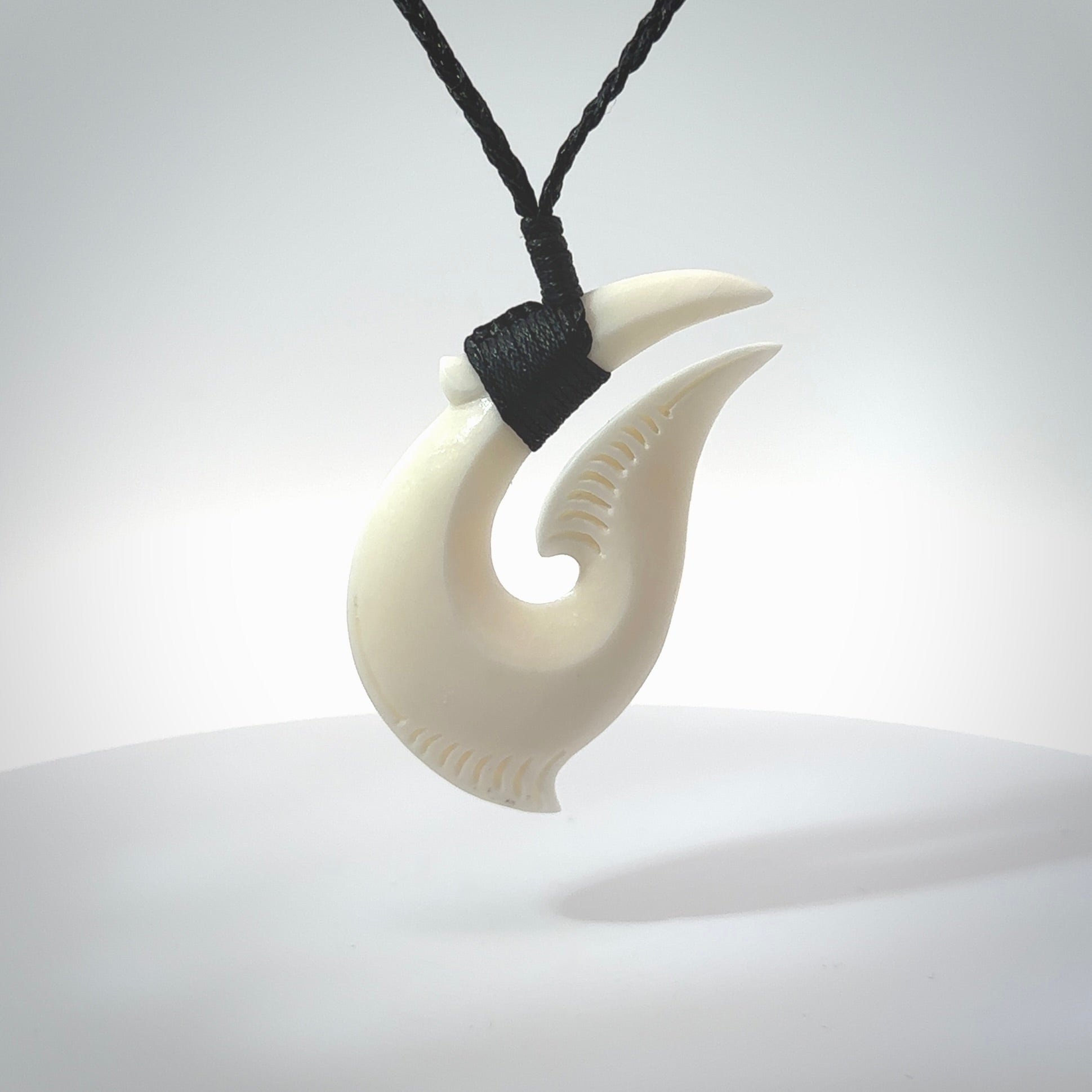Hand carved cow bone hook pendant. Maori matau carving, hand carved jewellery for sale online.