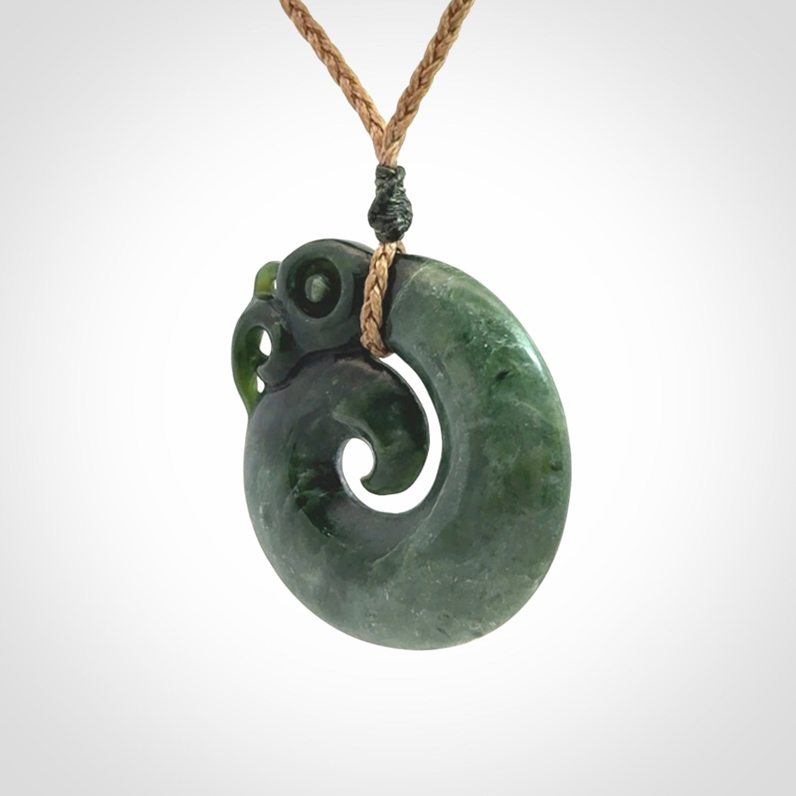 New Zealand Jade Koru Manaia. Hand carved Koropepe pendant. Made in New Zealand. Real Jade, pounamu. Real New Zealand Jade Manaia with Koru necklace with a polished finish.