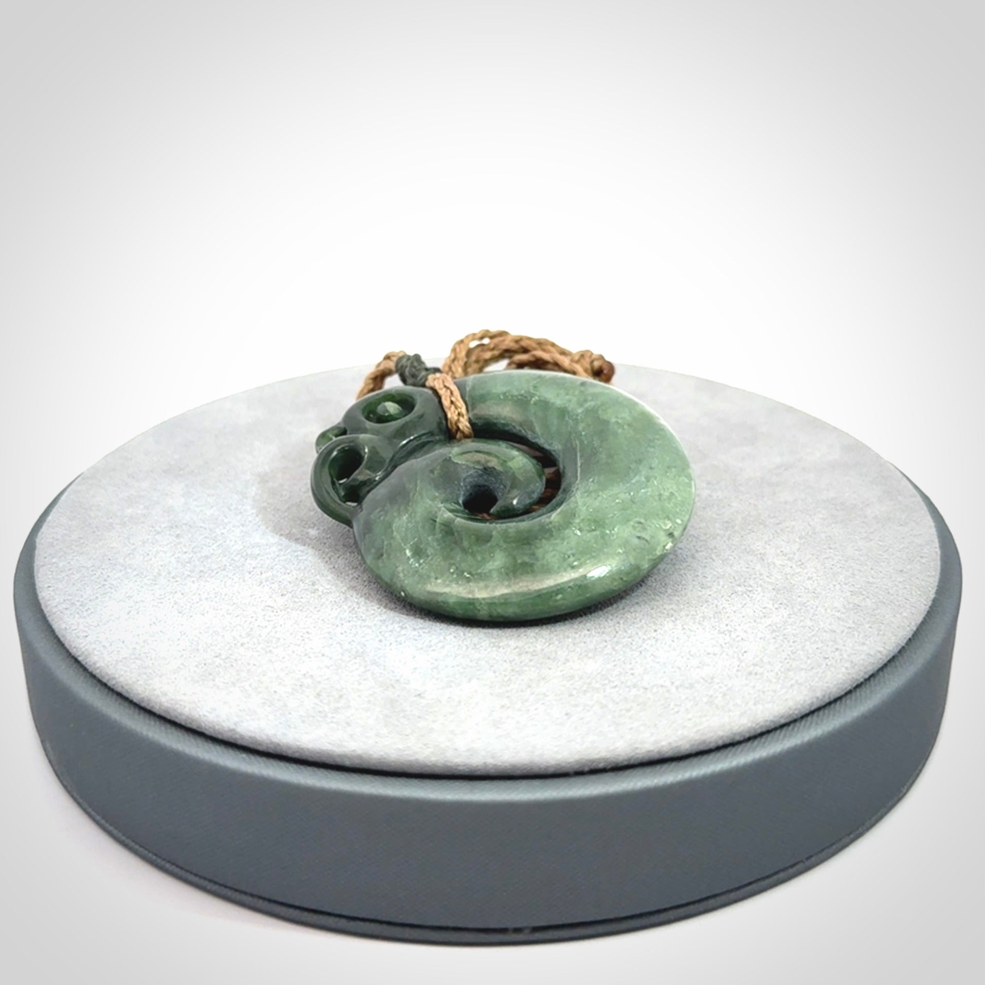 New Zealand Jade Koru Manaia. Hand carved Koropepe pendant. Made in New Zealand. Real Jade, pounamu. Real New Zealand Jade Manaia with Koru necklace with a polished finish.
