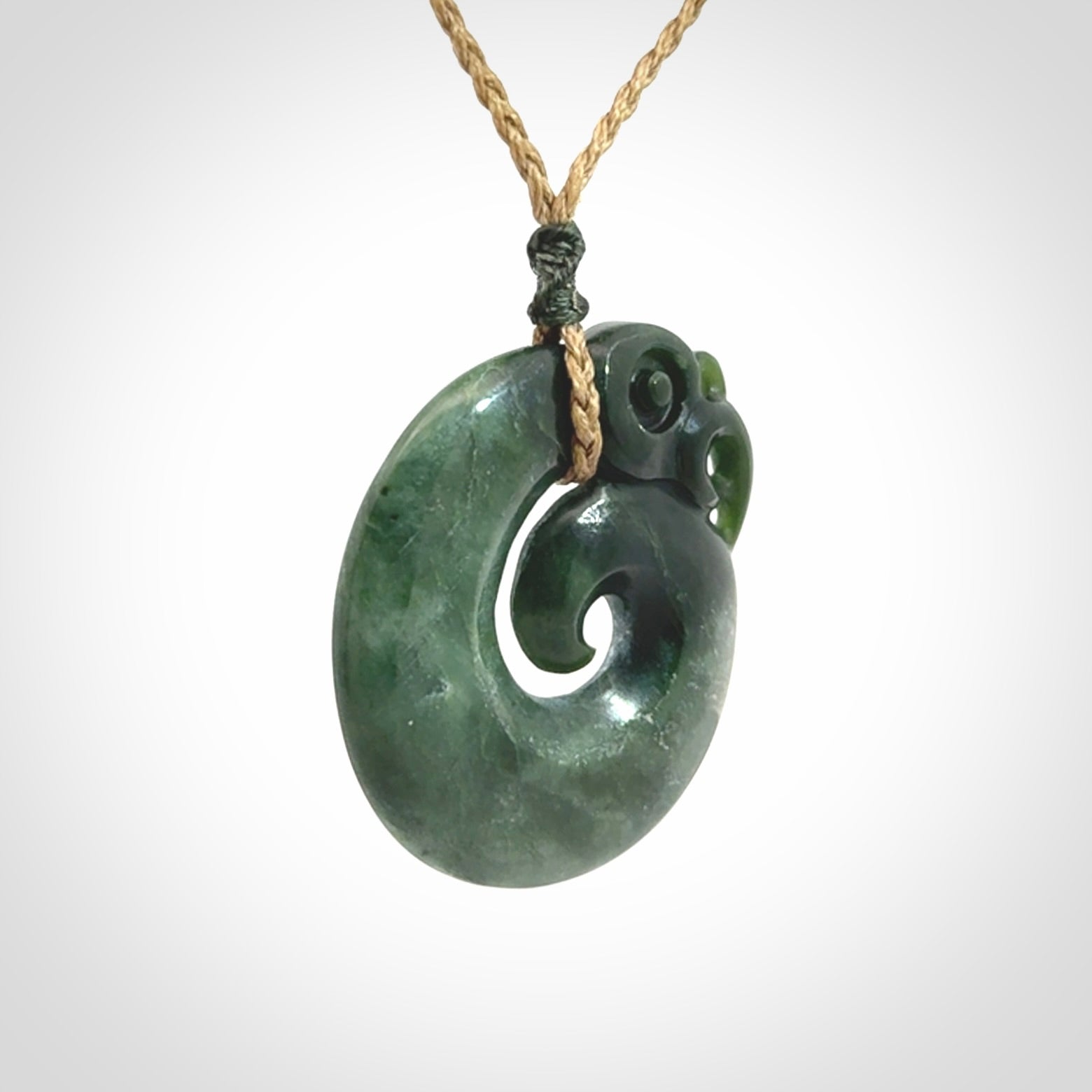 New Zealand Jade Koru Manaia. Hand carved Koropepe pendant. Made in New Zealand. Real Jade, pounamu. Real New Zealand Jade Manaia with Koru necklace with a polished finish.