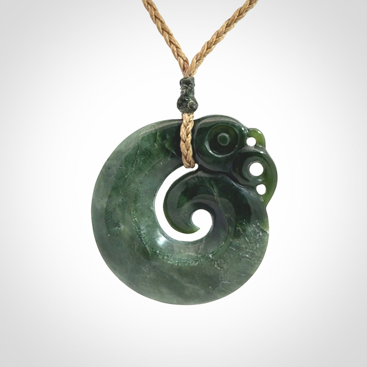 New Zealand Jade Koru Manaia. Hand carved Koropepe pendant. Made in New Zealand. Real Jade, pounamu. Real New Zealand Jade Manaia with Koru necklace with a polished finish.