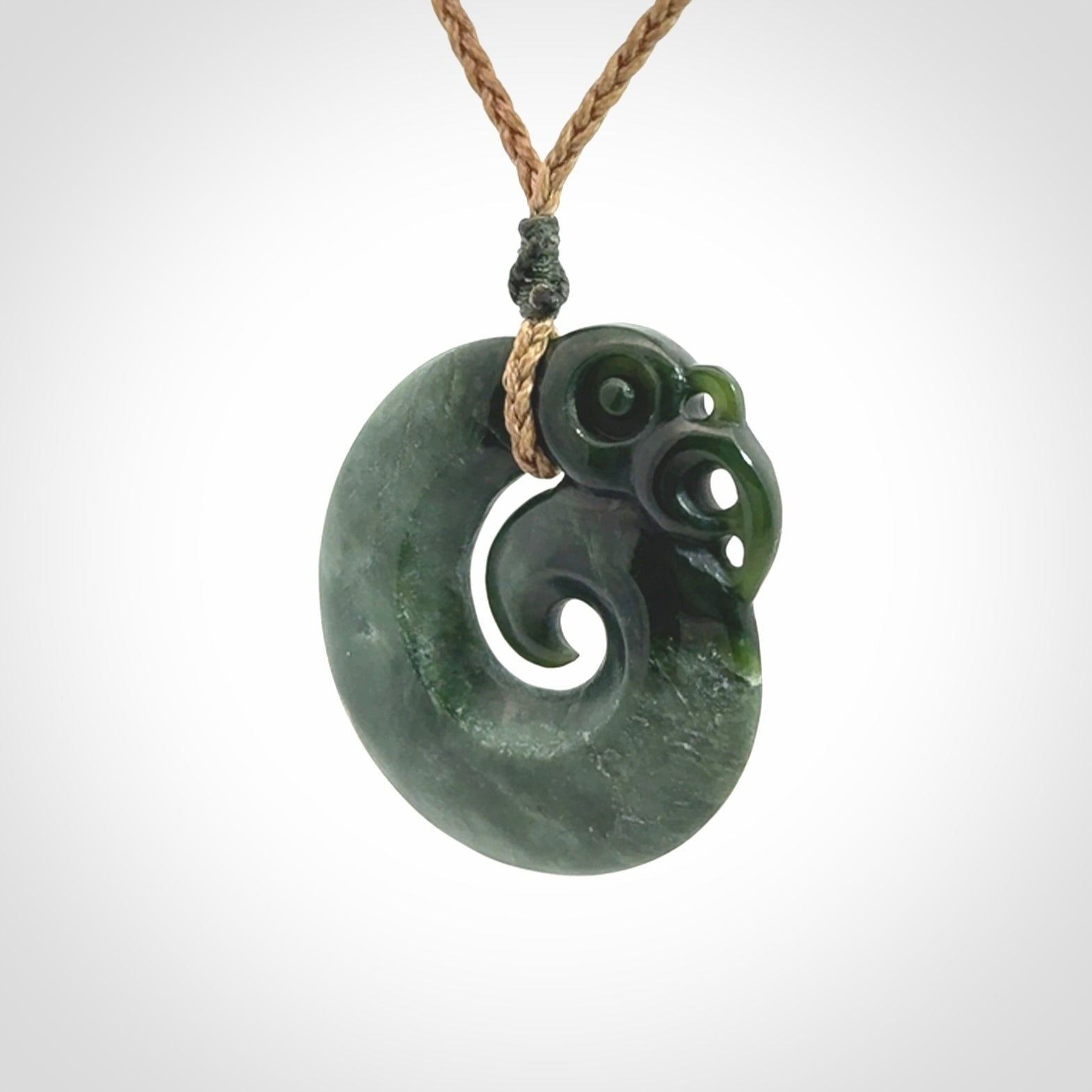 New Zealand Jade Koru Manaia. Hand carved Koropepe pendant. Made in New Zealand. Real Jade, pounamu. Real New Zealand Jade Manaia with Koru necklace with a polished finish.