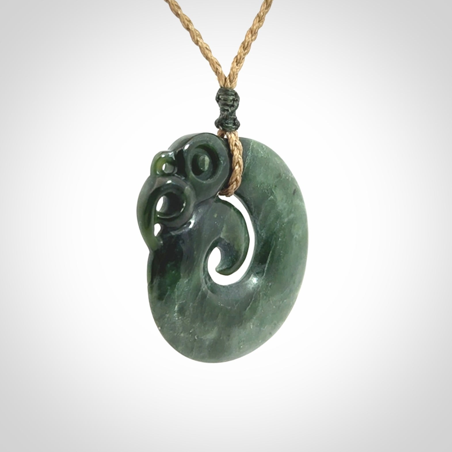 New Zealand Jade Koru Manaia. Hand carved Koropepe pendant. Made in New Zealand. Real Jade, pounamu. Real New Zealand Jade Manaia with Koru necklace with a polished finish.