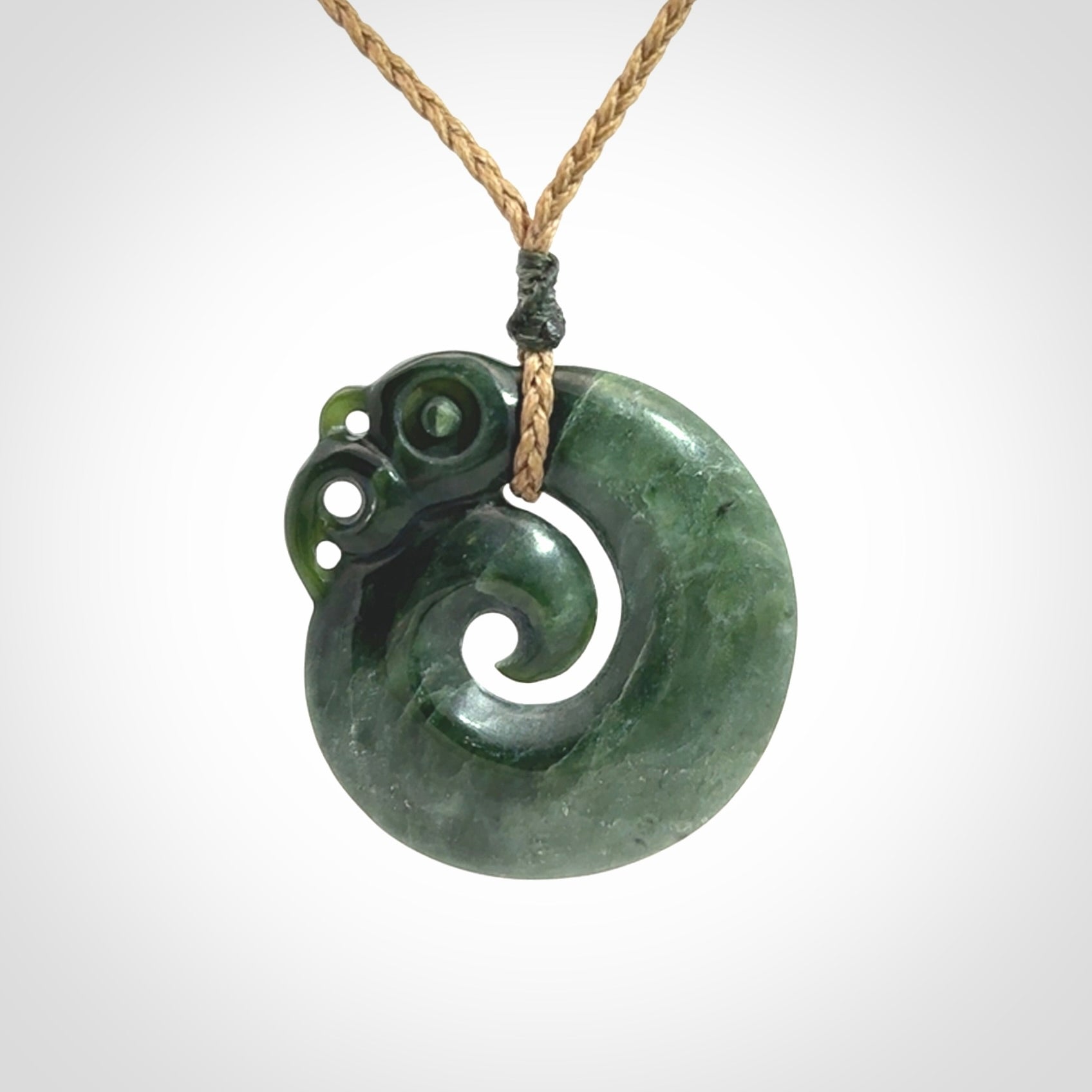 New Zealand Jade Koru Manaia. Hand carved Koropepe pendant. Made in New Zealand. Real Jade, pounamu. Real New Zealand Jade Manaia with Koru necklace with a polished finish.