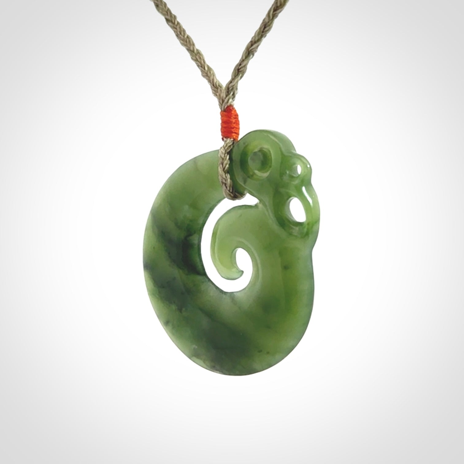 New Zealand Jade Koru Manaia. Hand carved Koropepe pendant. Made in New Zealand. Real Jade, pounamu. Real New Zealand Jade Manaia with Koru necklace with a polished finish.