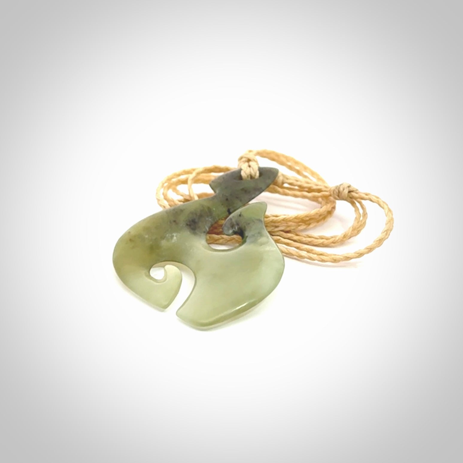 This photo shows a hook with koru pendant carved from New Zealand Jade. We provide this piece with an adjustable oat cord.