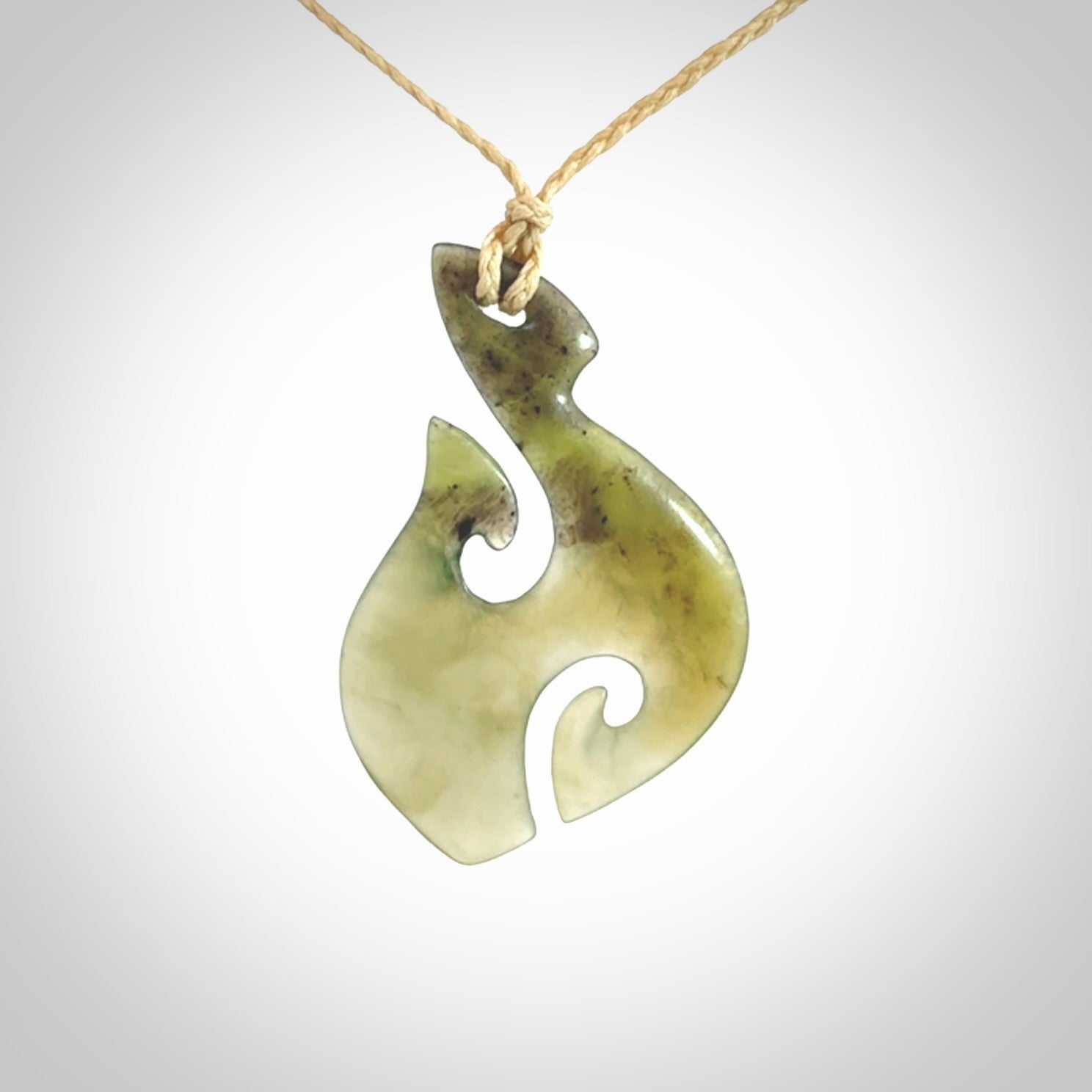 This photo shows a hook with koru pendant carved from New Zealand Jade. We provide this piece with an adjustable oat cord.