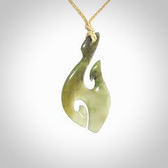 This photo shows a hook with koru pendant carved from New Zealand Jade. We provide this piece with an adjustable oat cord.