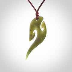 This photo shows a koru pendant carved from New Zealand Jade. We provide this piece with an adjustable plum cord.