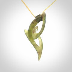 This photo shows a koru pendant carved from New Zealand Jade. We provide this piece with an adjustable oat coloured cord.