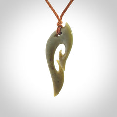 This photo shows a koru pendant carved from New Zealand Jade. We provide this piece with an adjustable gingernut brown coloured cord.